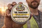Hand holding a jar of 'The Tradesman' heavy-duty hand balm with 'Job Site Junkies' branding.